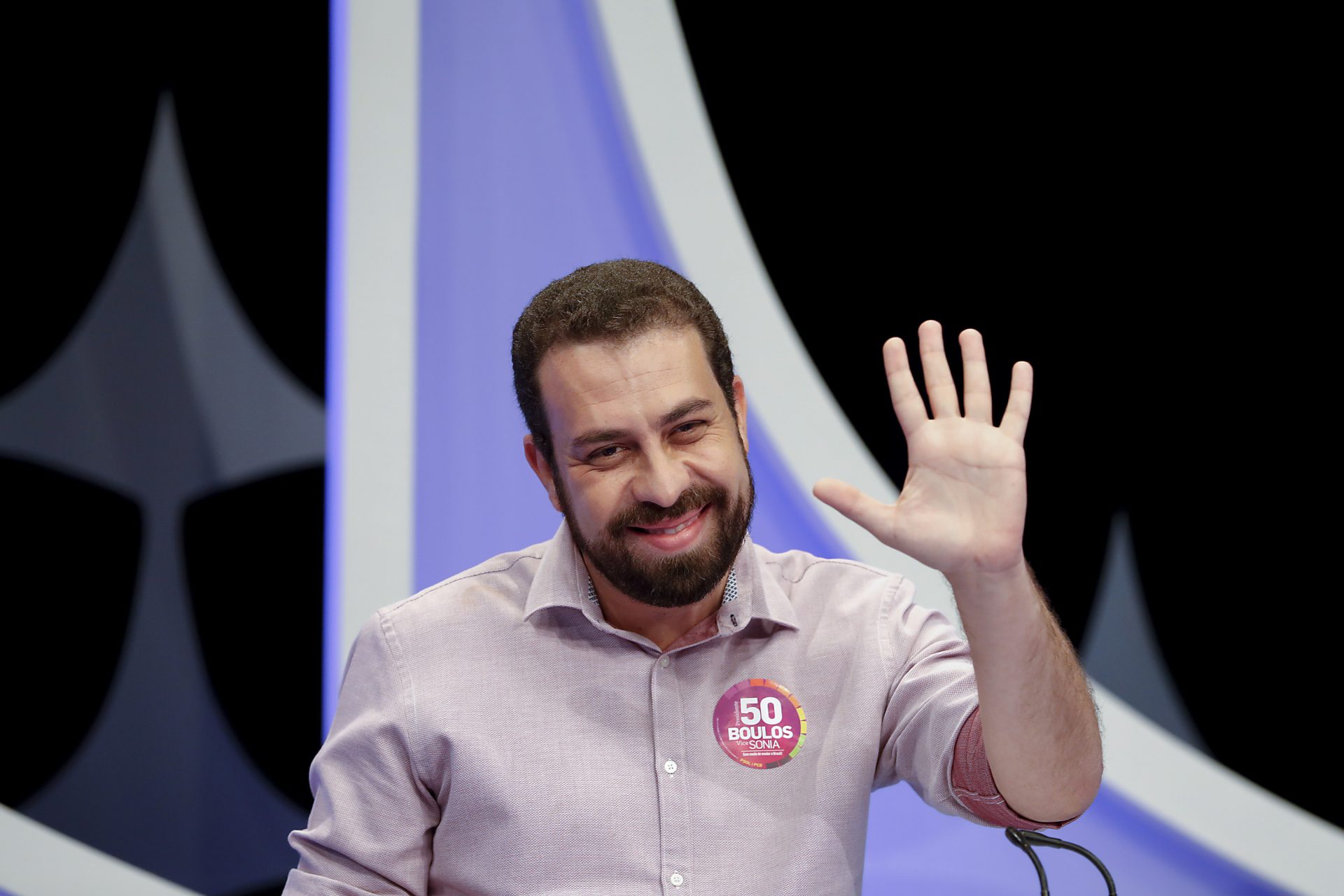 Guilherme Boulos (PSOL) acena a fotógrafos antes de debate no SBT