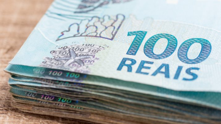 nota de dinheiro de 100 reais na mesa