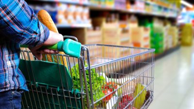 Supermercado, mulher com carrinho fazendo compras