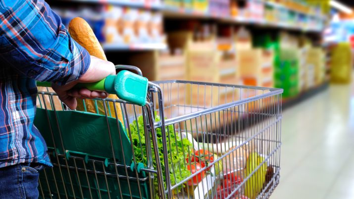 Supermercado, mulher com carrinho fazendo compras
