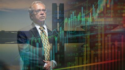 Paulo Guedes com os gráficos do Ibovespa ao fundo