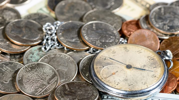 Moedas e um relógio antigo