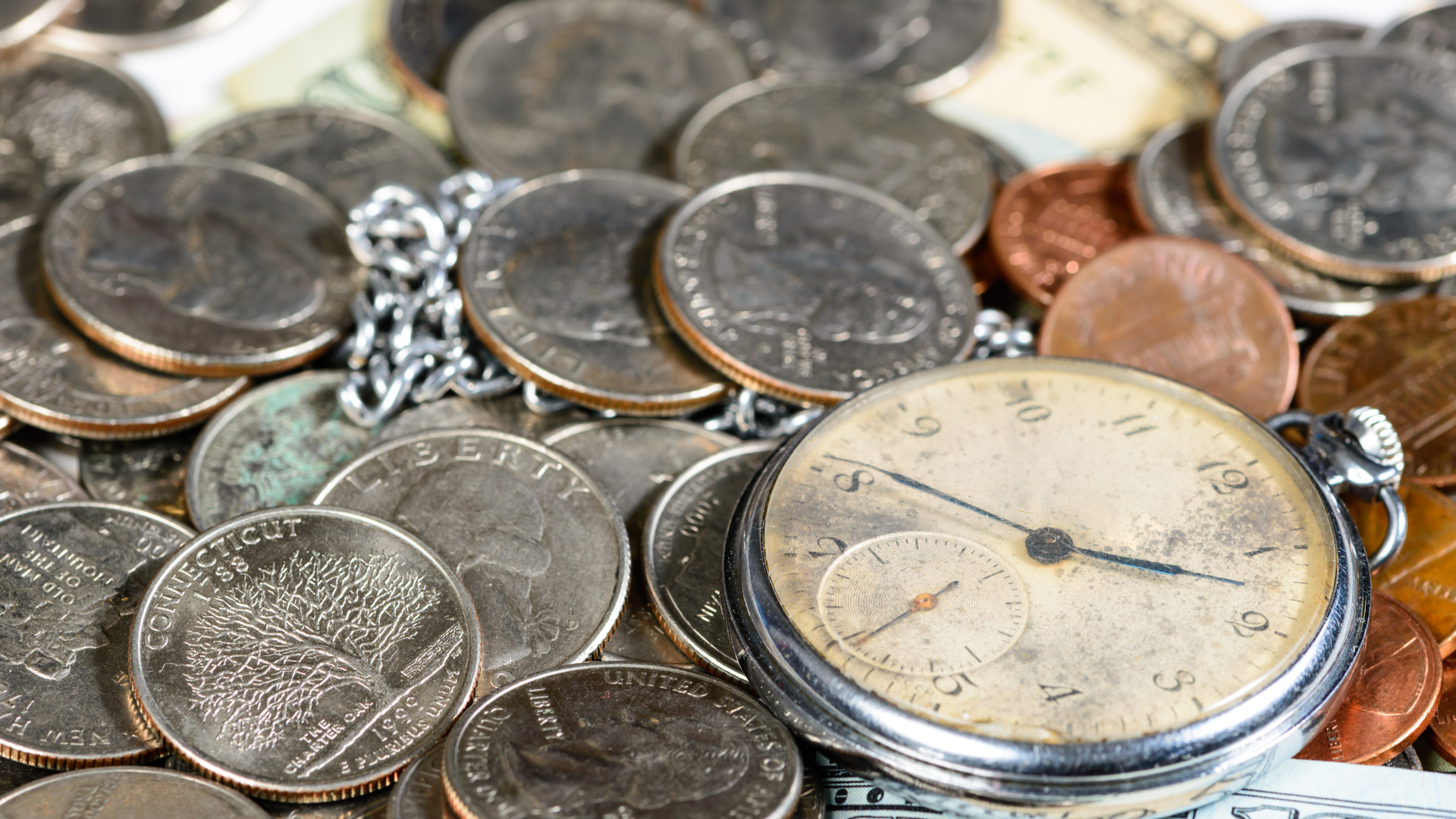Moedas e um relógio antigo
