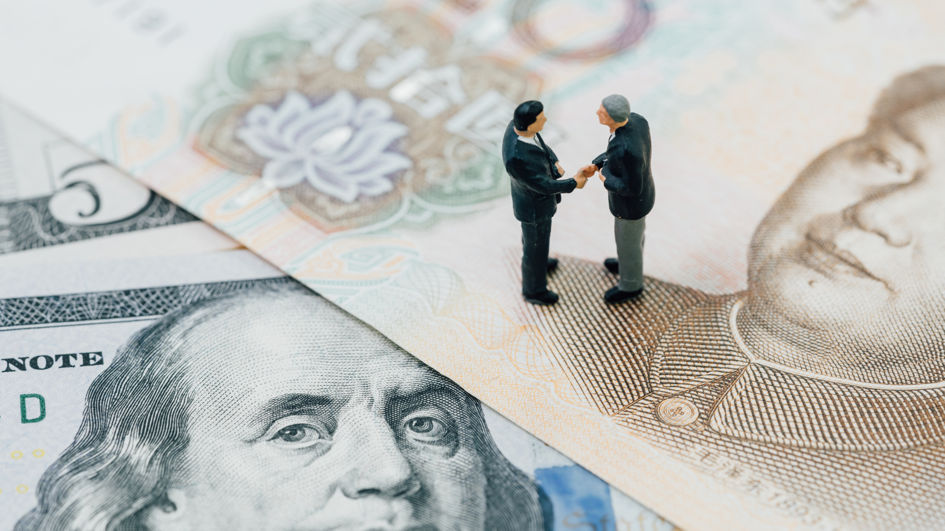 Montagem com dois bonecos dando as mãos, sinalizando um acordo entre EUA e China