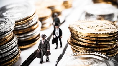 Imagem mostra miniaturas de bonecos ao lado de moedas