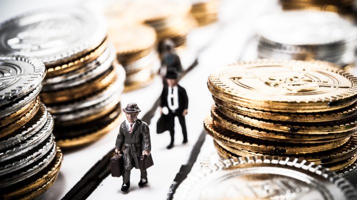 Imagem mostra miniaturas de bonecos ao lado de moedas