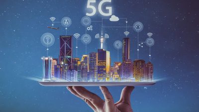 Mão segura bandeja com prédios conectados emulando rede 5g