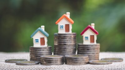 Mini,House,On,Stack,Of,Coins,,Concept,Of,Investment,Property,