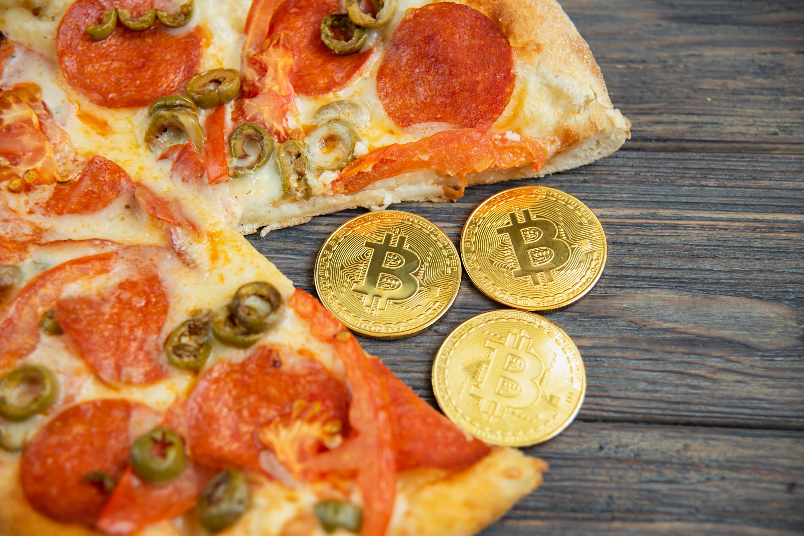 Pizza com moedas ilustrativas de Bitcoin