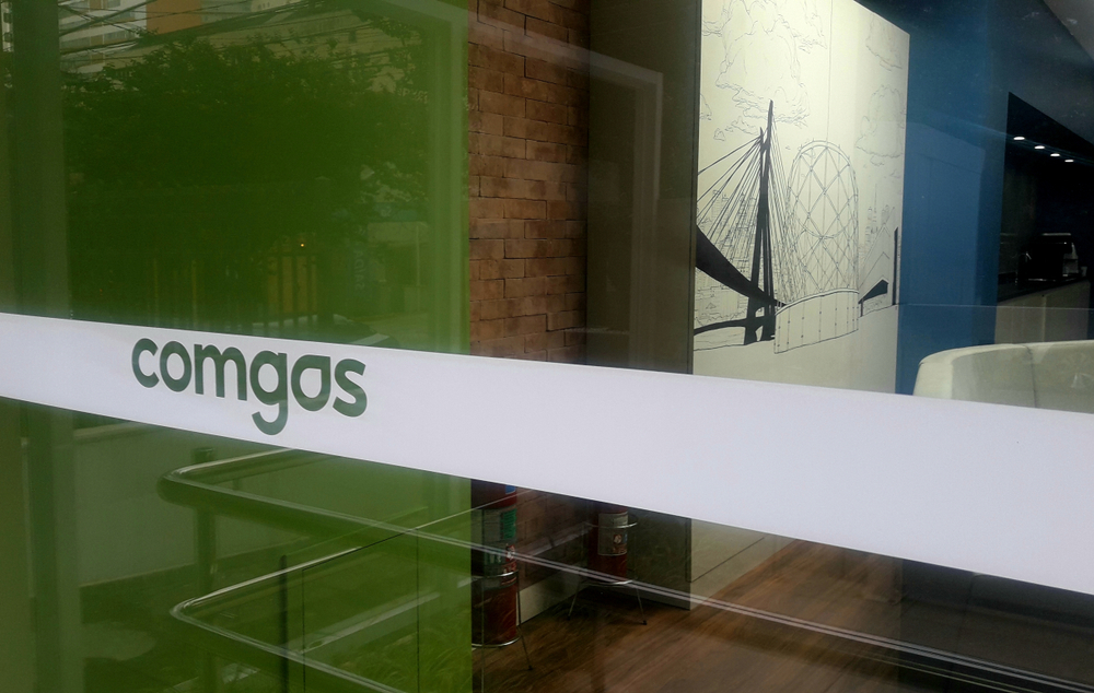 Imagem de uma porta de vidro com o logo da Comgás adesivado. A empresa faz parte da Compass, subsidiária da Cosan (CSAN3) que concentra os ativos de óleo e gás do conglomerado