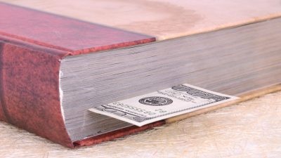 Closed,Brown,Book,With,A,Bookmark,100,Dollars,On,The