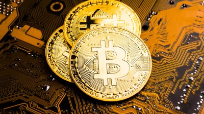 Golden,Coins,With,Bitcoin,Symbol,On,A,Mainboard.