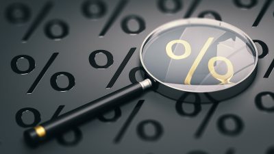 Arte mostrando uma lupa focalizando um símbolo de porcentagem; indicação para matérias envolvendo juros, Selic, Banco Central (BC), investimentos e outros