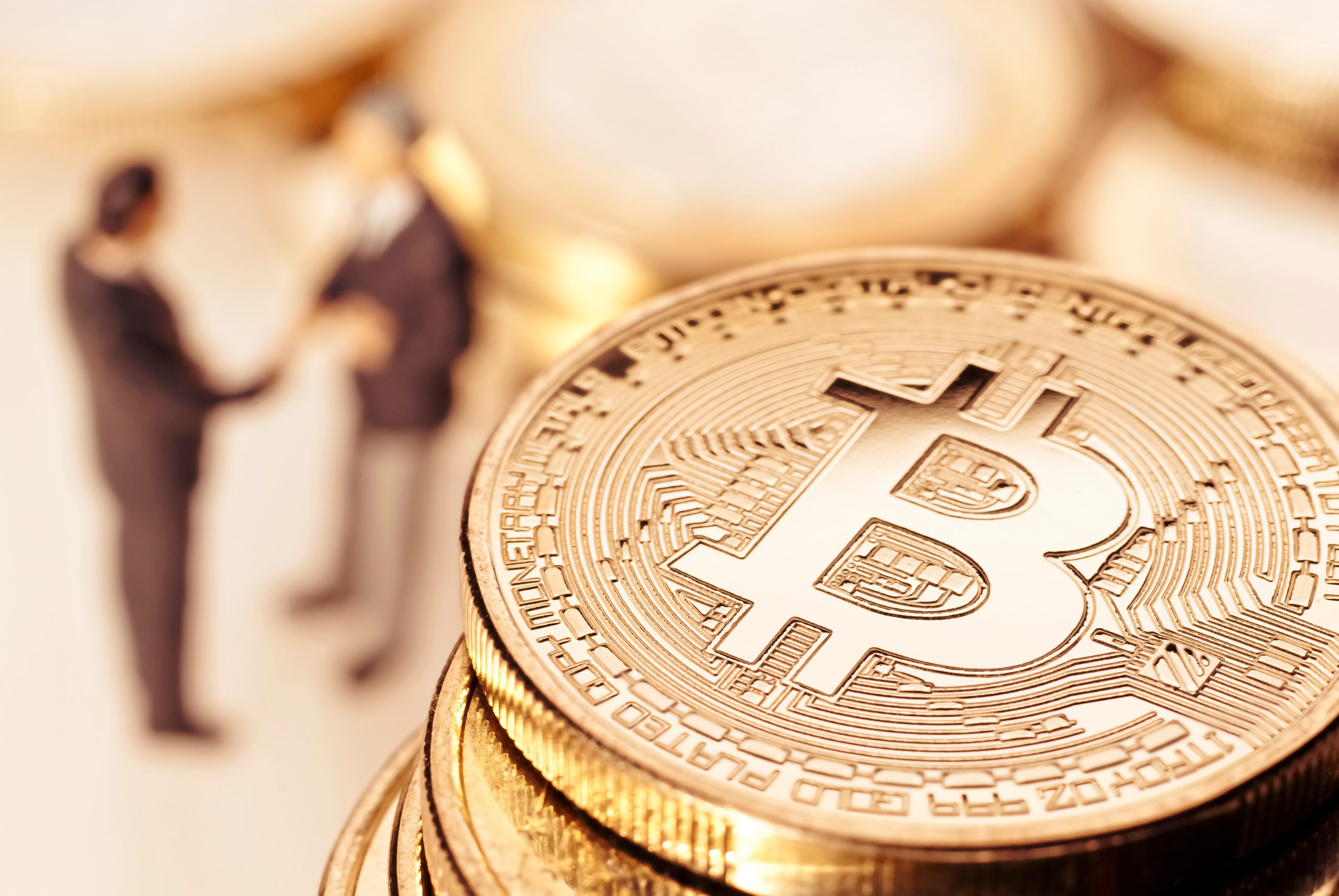Imagem de bitcoin com homens se cumprimentando ao fundo