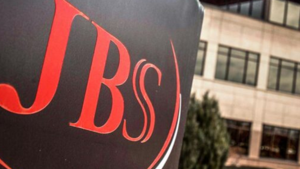 Imagem mostra a placa do frigorífico JBS (JBSS3) com um prédio ao fundo | Irmãos Batista dividendos
