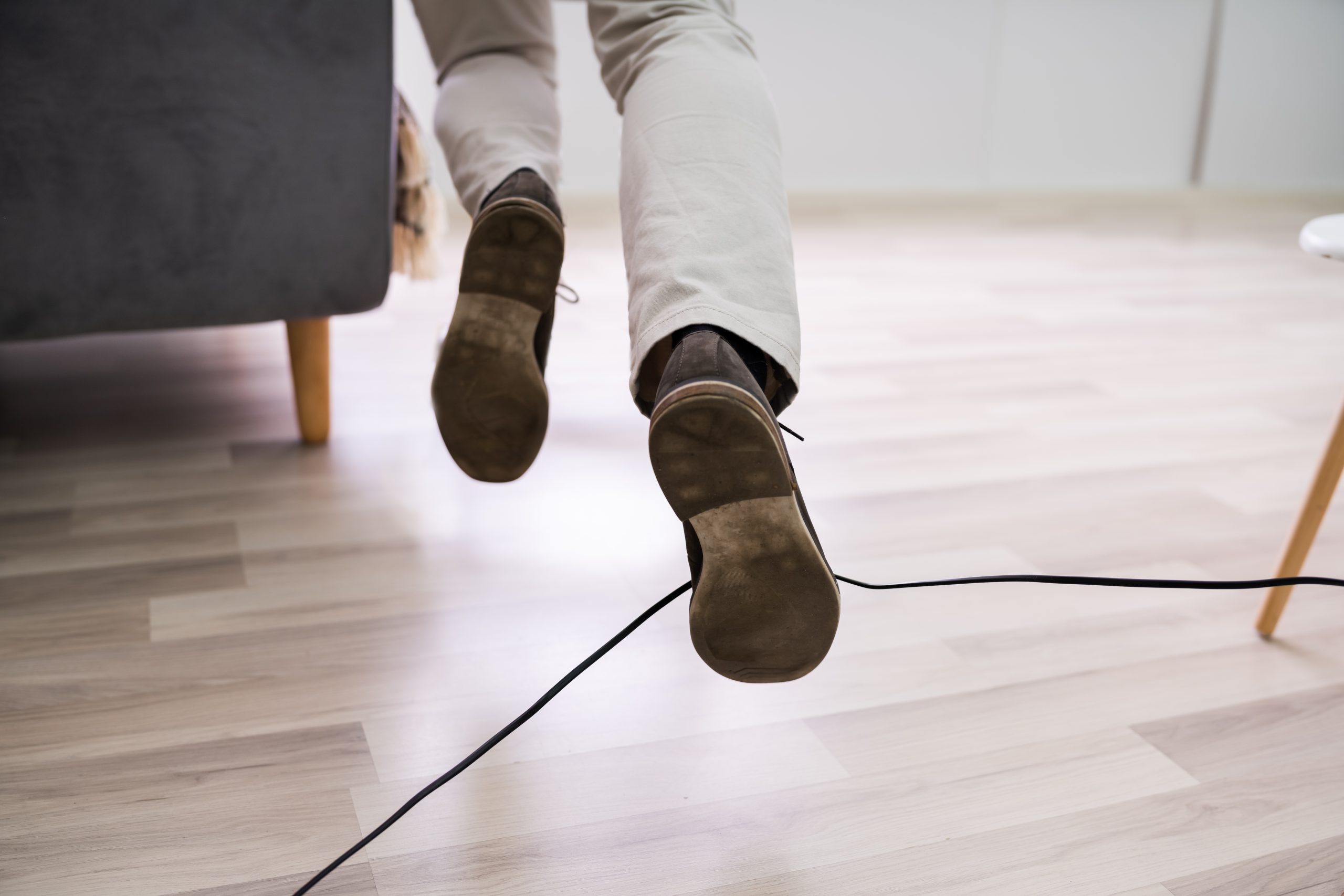 Close-up,Of,A,Man,Legs,Stumbling,With,An,Electrical,Cord