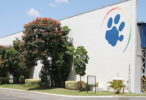 Fachada branca com o símbolo da empresa Tigre, uma pata felina azul
