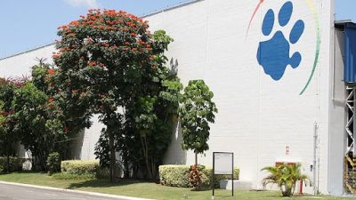 Fachada branca com o símbolo da empresa Tigre, uma pata felina azul