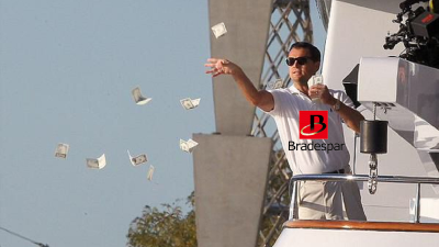 Montagem com o ator Leonardo DiCaprio no filme "O Lobo de Wall Street", usando uma camisa com o logo da Bradespar (BRAP4). Na cena, ele joga notas de dólar de uma sacada, representando a distribuição de dividendos e ações da Vale (VALE3) | Dividendos