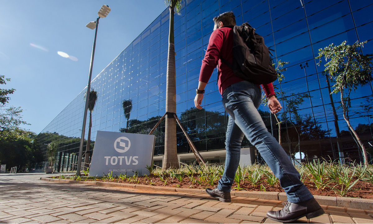 Foto de um homem passando em frente à fachada da sete da Totvs (TOTS3), em São Paulo