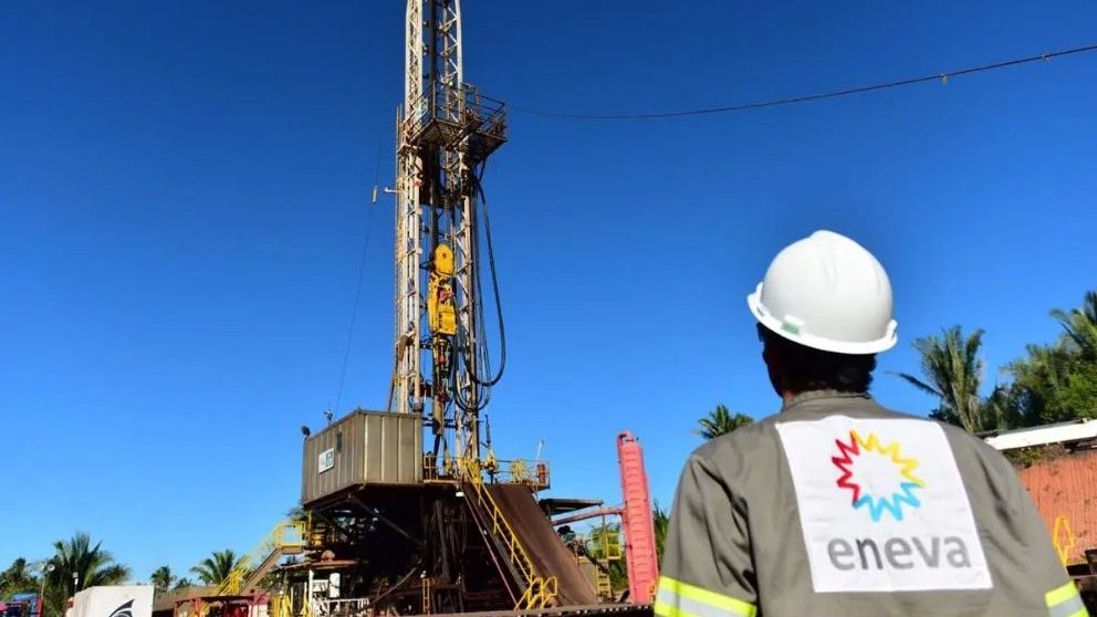 Funcionário com o uniforme da Eneva olhando para uma contsrução metálica