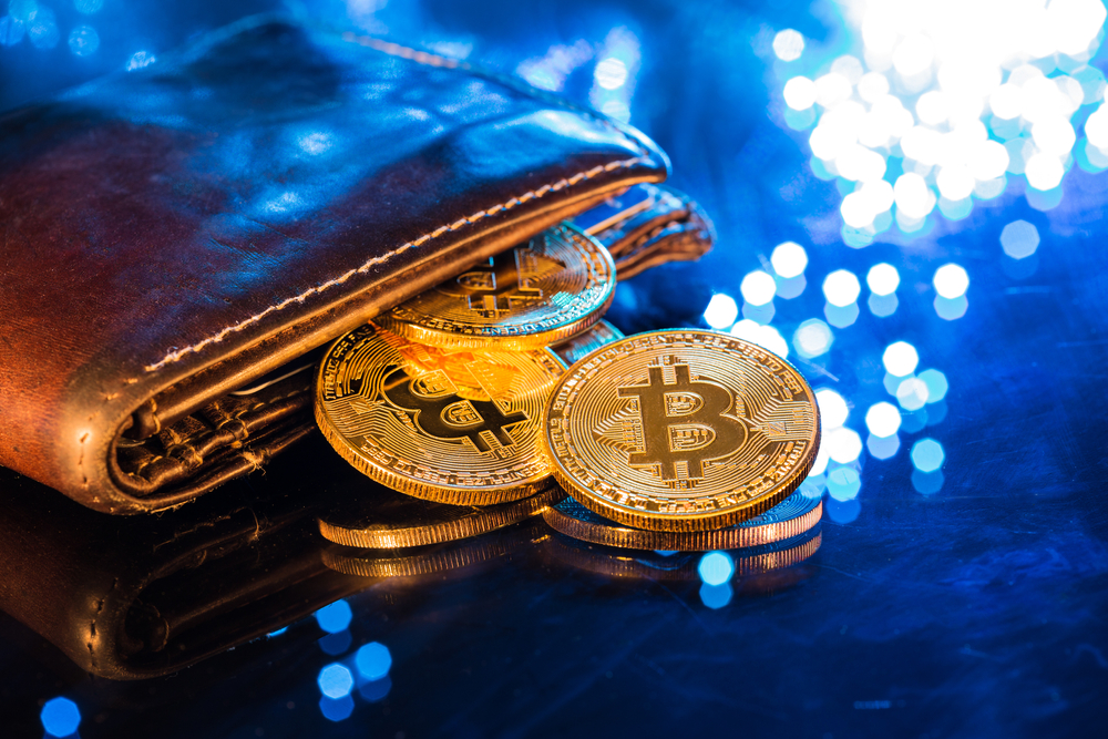 Carteira com moeda simbolizando o bitcoin