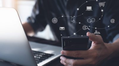 Tecnologia: Homem segurando um celular rodeado de ícones de e-mail, download, computador, pesquisa na internet, bate-papo, localização e mais