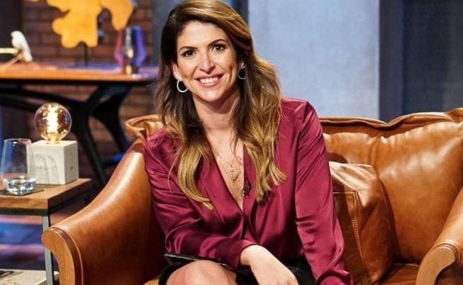 Imagem de Carol Paiffer sentada em uma poltrona de couro