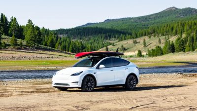 Carro elétrico Tesla Model Y com uma prancha de surfe