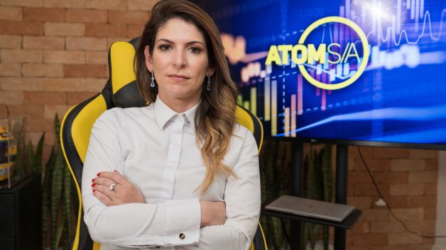 carol paiffer em frente ao logo da atom s/a
