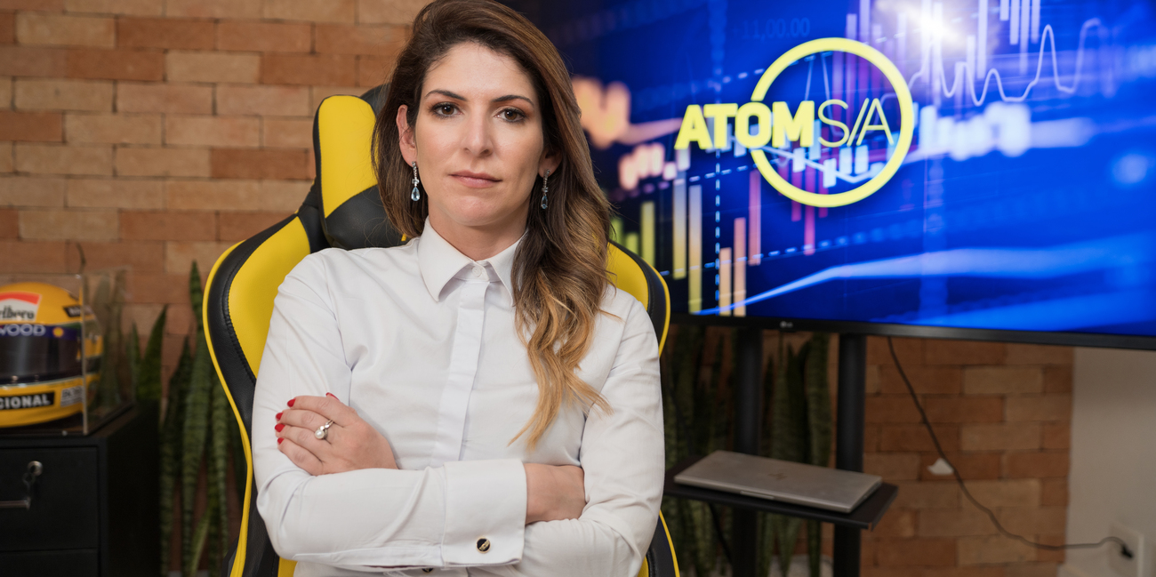 carol paiffer em frente ao logo da atom s/a