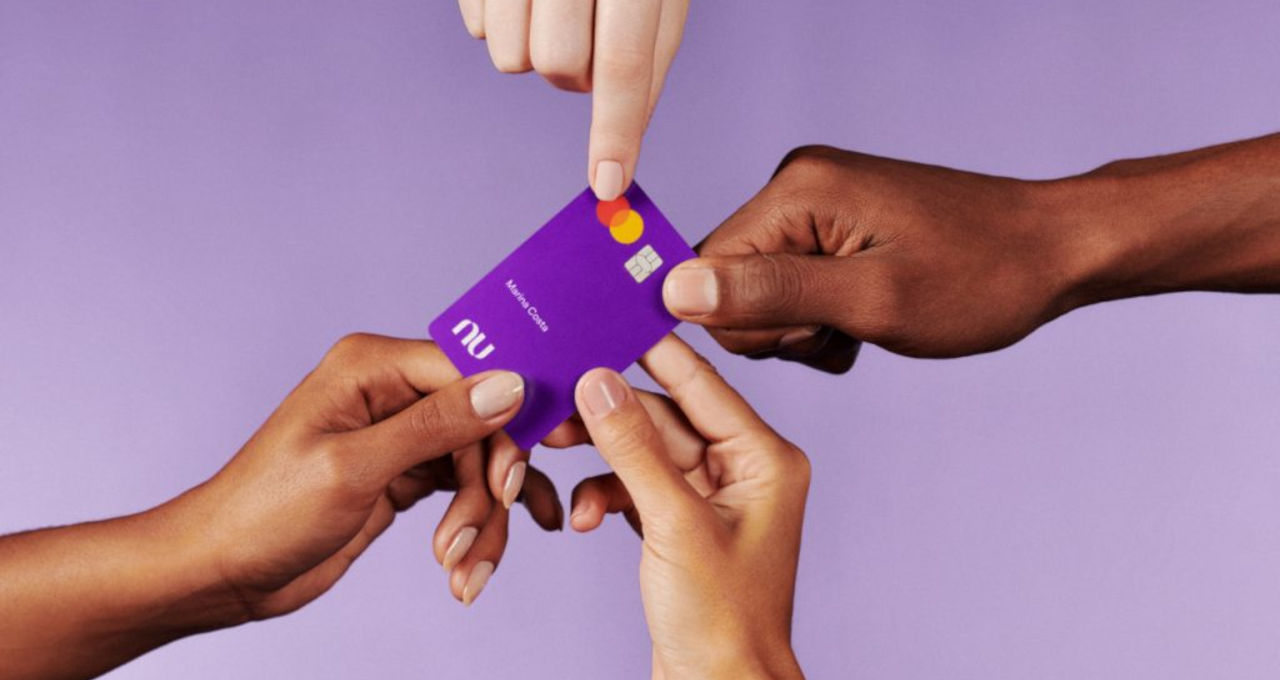 Mãos seguram cartão do Nubank