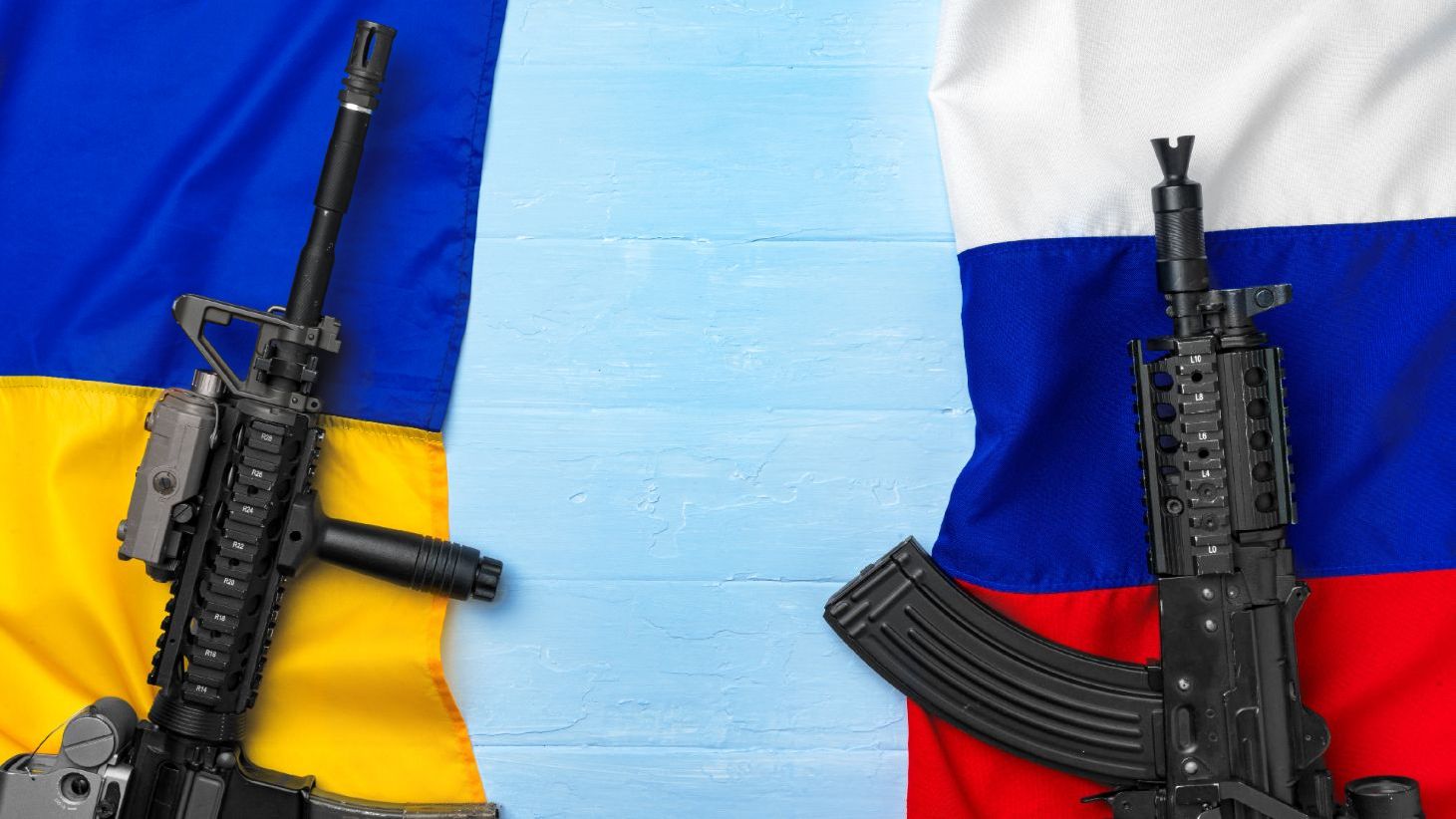 Bandeiras da Ucrânia e da Rússia com armas simbolizando conflito