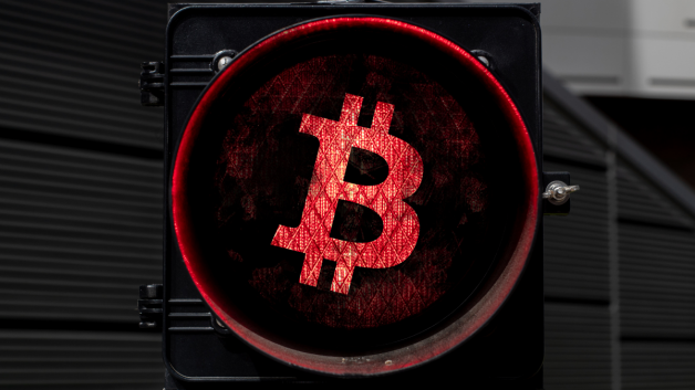 Bitcoin em uma luz vermelha sinalizando a parada do mercado de criptomoedas