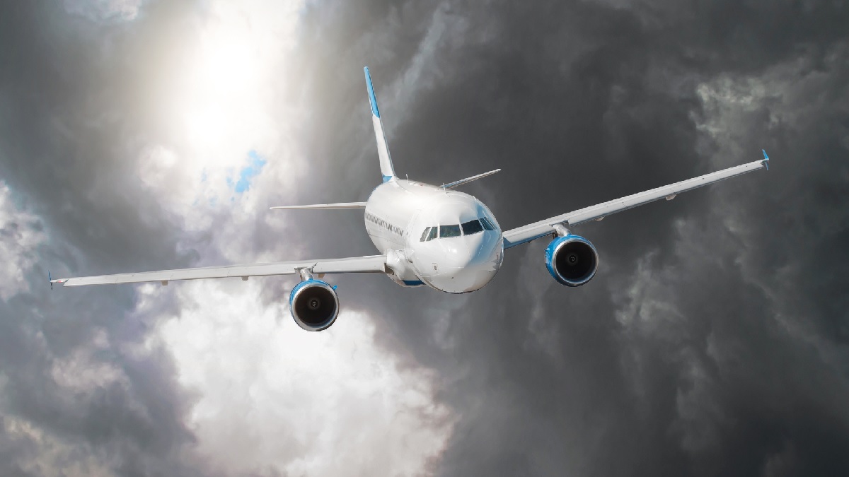 Avião sobrevoando um céu cinzento e carregado, simbolizando problemas no setor aéreo ações aéreas