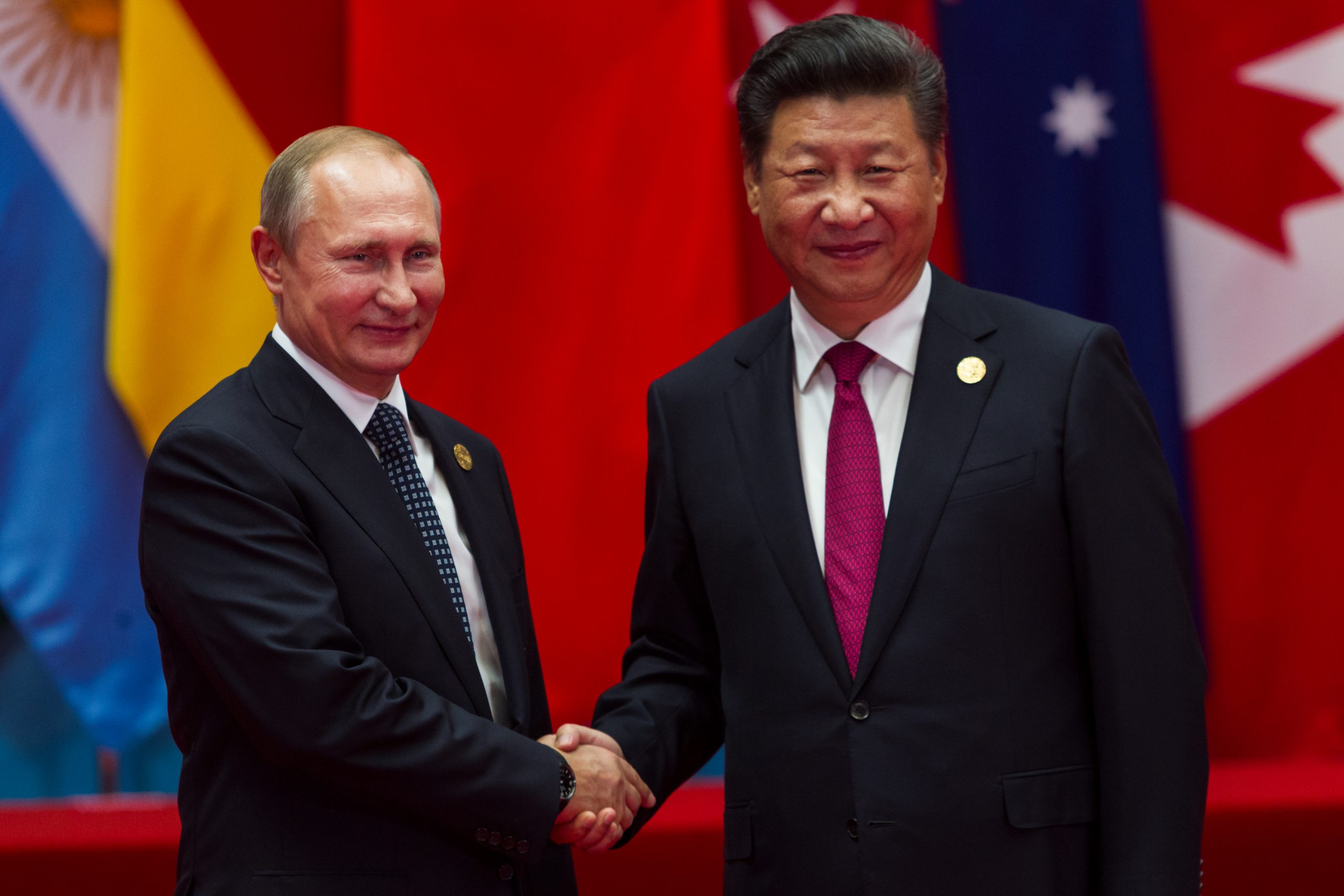 O presidente da Rússia, Vladimir Putin, cumprimenta com um aperto de mãos o presidente da China, Xi Jinping