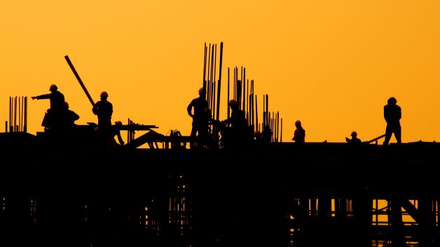 Silhueta de trabalhadores da construção civil no pôr do sol | Construtoras, Cury, PDG PDGR3, ações JP Morgan Casa Verde e Amarela Distratos TENDA Santander Ações ação