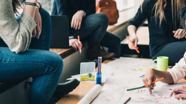 pessoas sentadas em volta de uma mesa de programas de estágio e trainee