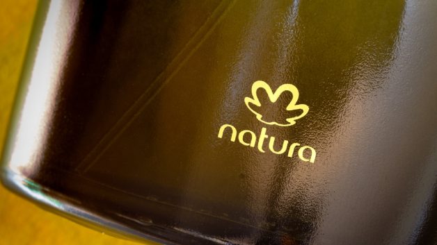 Zoom em um frasco de perfume Natura (NTCO3), com o logo da empresa em destaque