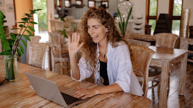 mulher acenando para o computador indicando o início de uma das entrevistas de emprego