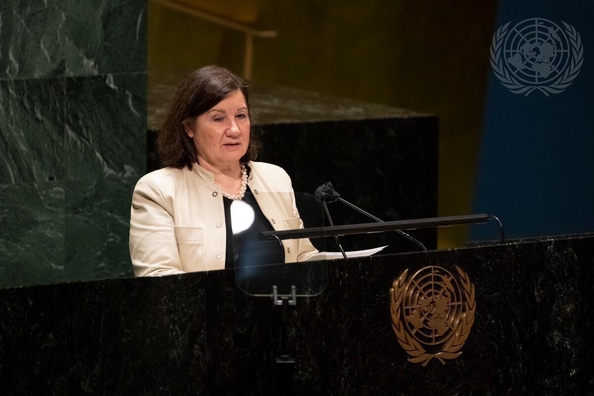 Mulher de pé, em frente a um púlpito discursando