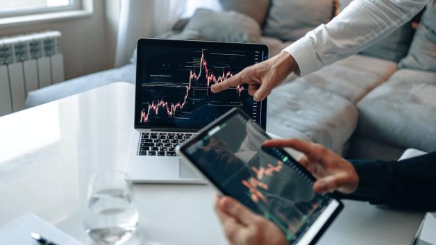 Gráficos da bolsa em tela de computador e de tablet