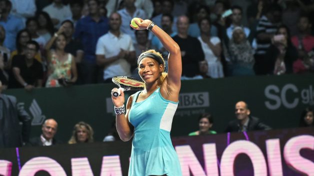 serena williams, tenista mundial em quadra, com a bola de tênis em uma das mãos erguida e a outra mão com raquete. Ela anunciou a aposentadoria e vai se dedicar ao mundo dos investimentos