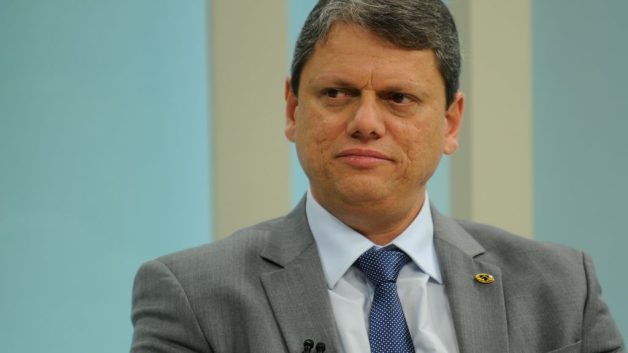 Foto de meio corpo de homem vestido terno cinza, camisa branca e gravata azul