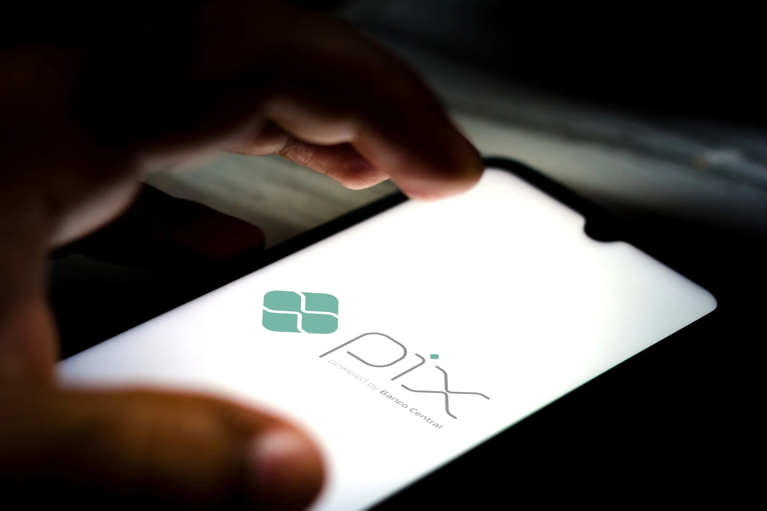 Celular exibindo o logo do Pix, sistema de transferências instantâneas do Banco Central