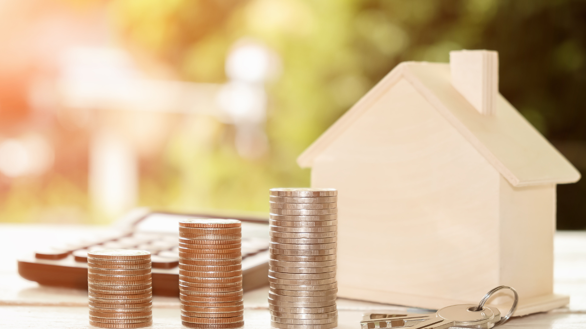 Imagem mostrando pilhas de moedas em frente a uma maquete de uma residência, representando os fundos imobiliários (FIIs)