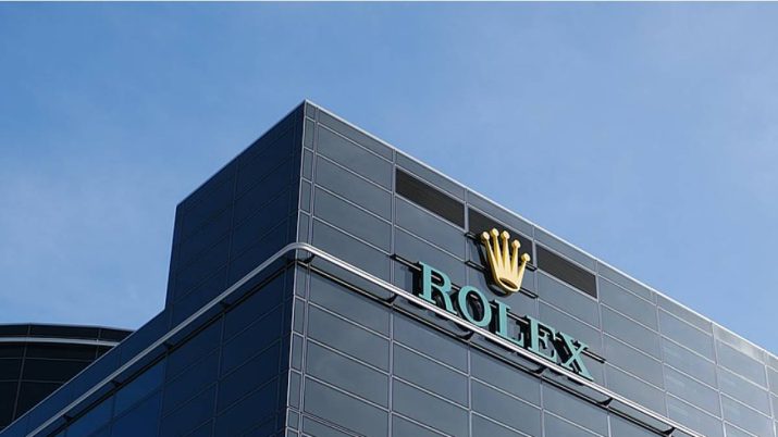 Prédio de vidro com o logo da Rolex no topo