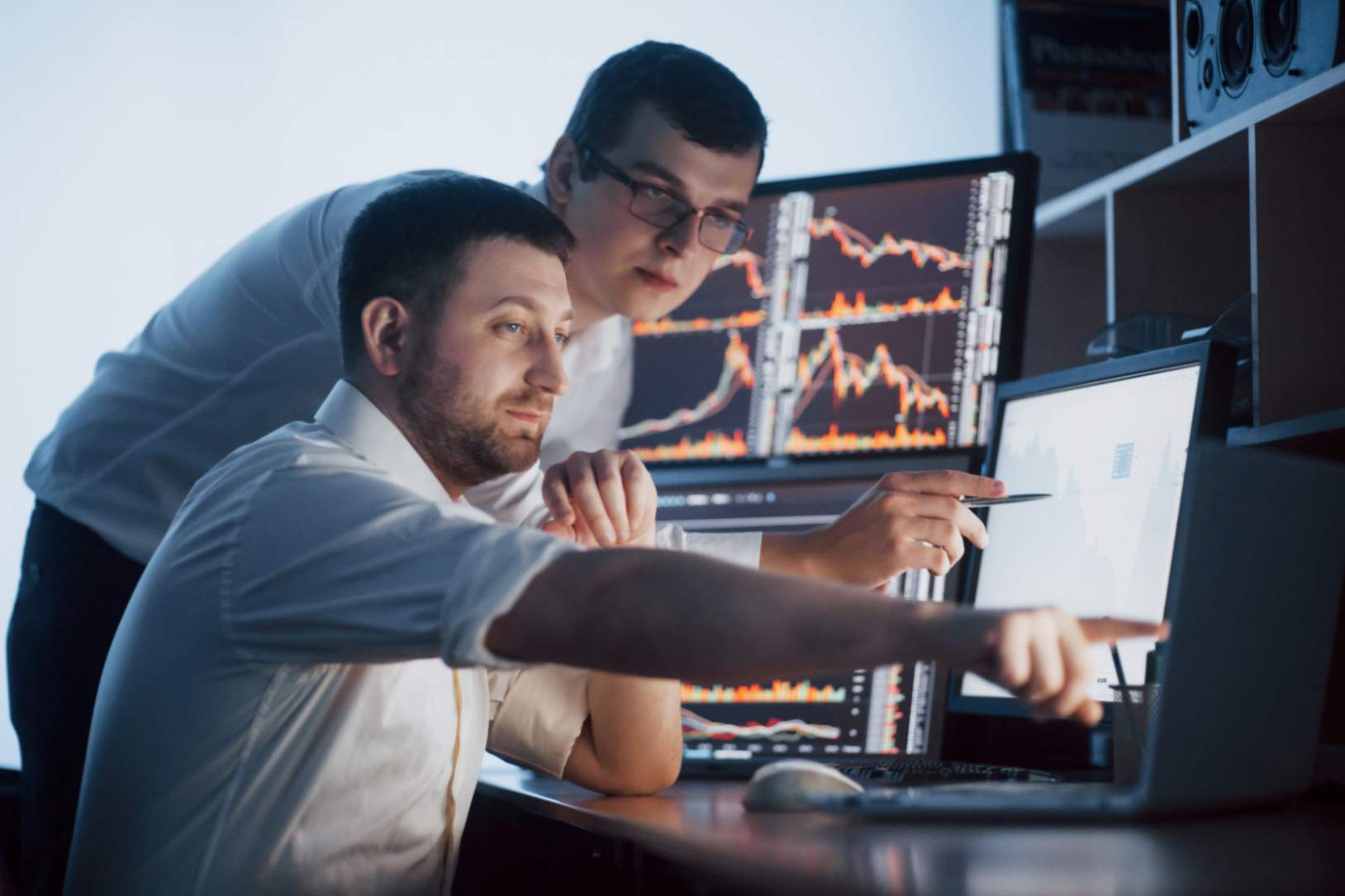 profissionais-conversando-em-um-escritorio-escuro-com-telas-analisando-dados-graficos-e-relatorios-para-fins-de-investimento-comerciantes-de-trabalho-em-equipe-criativa