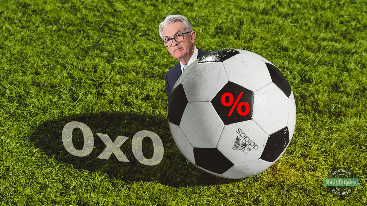 Em um gramado, aparece um placar com zero a xero, uma bola de futebol com uma % no centro e o presidente do Federal Reserve, Jerome Powell, escondido atrás da bola