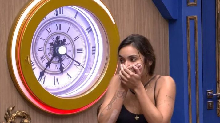 A influencer digital Vanessa Lopes está com as mãos na boca ao lado do botão de desistência do BBB 24